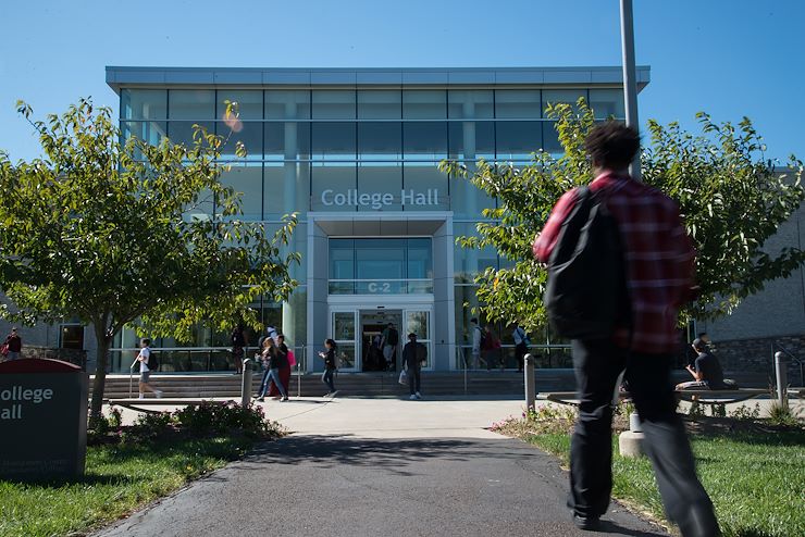 Student walking towards the College Hall building on the Montco Blue Bell Campus