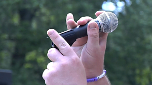 Hand placing a microphone onto the stand