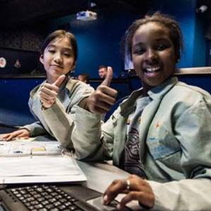 Kids sitting at the Challenger Center command desk