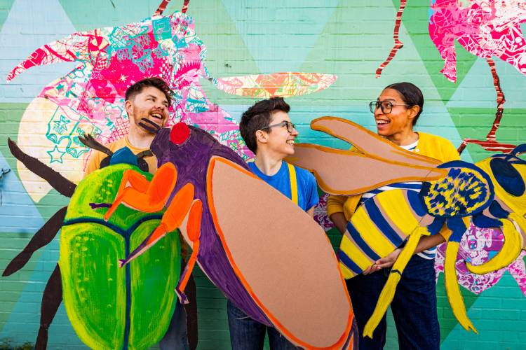 Play actors from "Alpha Bugs" holding up large bug characters