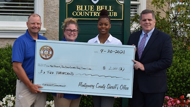 Deputy Chief Adam Berry, left, and Sheriff Sean Kilkenny, right, present Deputy Kayla Lochner-Franz and Siana Sanders with the Montgomery County Sheriff's Office scholarship award check.