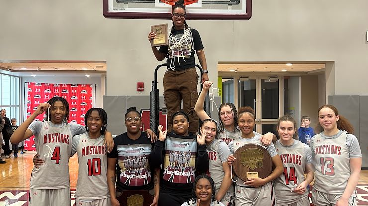 The Montgomery County Community College Mustangs women’s basketball team celebrates their historic victory after defeating Rowan College of South Jersey, Gloucester, 48-42 to win the North Atlantic District Championship—securing their first-ever Regional Championship and a spot in the NJCAA Division III National Championship tournament. Photo by Kelly Dunbar