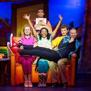 Five “Pete the Cat” performers sit on stage on a couch. One is dressed like a cat.