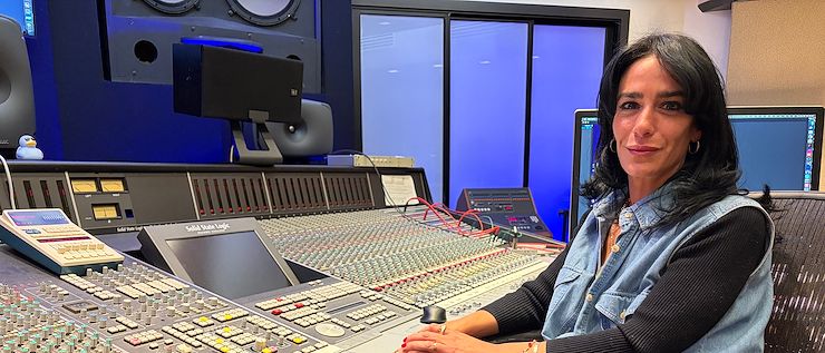 Mia Fanelli sits at a mixing board in the Mix Room on the Blue Bell Campus